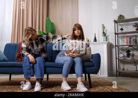 Mère fille conflit. Femme d'âge moyen essayant de parler à sa fille adulte offensé, assise ensemble sur un canapé à la maison Banque D'Images