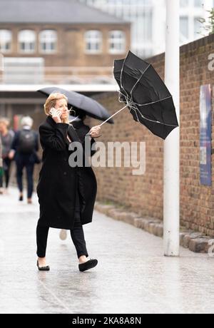 Les gens marchent à travers la petite Venise, Londres pendant les vents forts et la pluie. Alors que Storm Claudio bat la capitale. Date de la photo: Mardi 1 novembre 2022. Banque D'Images