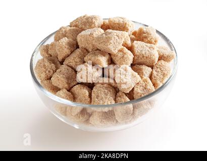 Cubes de sucre de canne à sourcils dans un bol en verre isolé sur fond blanc avec passe-cheveux Banque D'Images