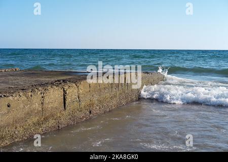 Vagues heurtant des pierres d'un ancien quai Banque D'Images