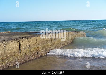 Vagues heurtant des pierres d'un ancien quai Banque D'Images