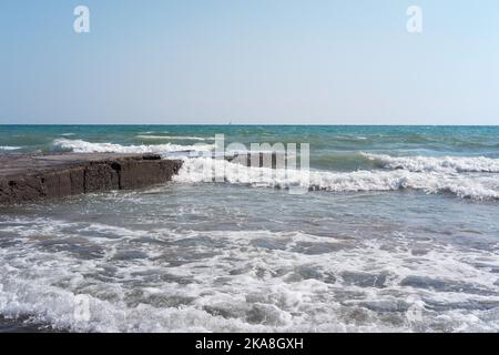 Vagues heurtant des pierres d'un ancien quai Banque D'Images