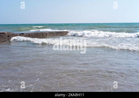 Vagues heurtant des pierres d'un ancien quai Banque D'Images