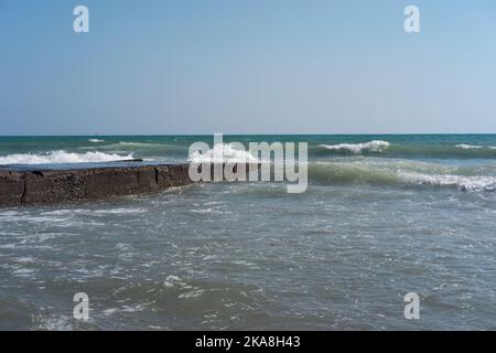 Vagues heurtant des pierres d'un ancien quai Banque D'Images