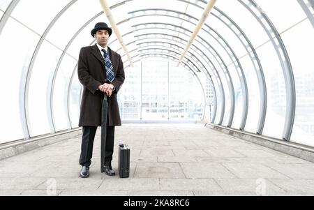 Le City Gent, style d'affaires. Un homme d'affaires londonien traditionnel avec chapeau melon dans un environnement urbain moderne. À partir d'une série d'images associée. Banque D'Images