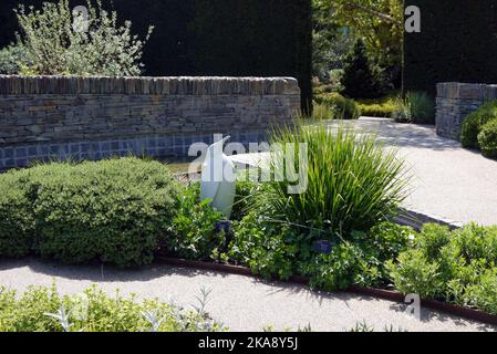 Une sculpture de pingouin blanc à la frontière du Cool Garden à RHS Garden Rosemoor, Torrington, North Devon, Angleterre, Royaume-Uni Banque D'Images