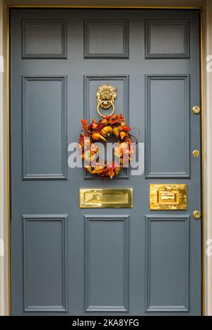 Couronne de récolte saisonnière sur la porte avant à panneaux géorgiens ; boîte aux lettres et knocker en laiton, Edinburgh New Town, Écosse, Royaume-Uni Banque D'Images