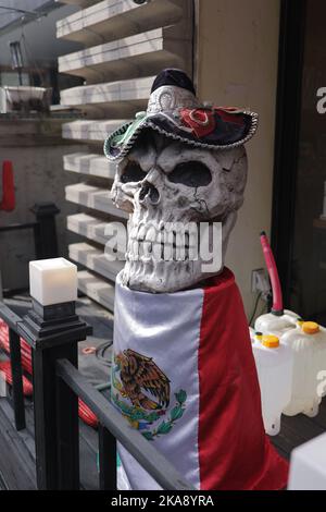 Un cliché vertical d'un crâne avec un chapeau de pirate enveloppé dans le drapeau mexicain dans un magasin d'antiquités Banque D'Images