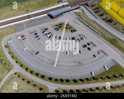 Vue aérienne du train, de la gare, avec places de parking, places, parking pour les navetteurs. Photographie de drone prise de dessus en Suède en mai. Banque D'Images