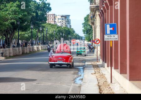 Une voiture de taxi décapotable d'époque cassée est à l'arrêt à El Paseo del Prado. La rue est très peu fréquentée. Un panneau indique « Hotel in con Banque D'Images