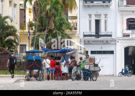 Un groupe de Cubains se trouve dans la partie arrière d'un camion qui vend des produits alimentaires dans une rue de ville. Banque D'Images