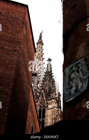 Photo en petit angle de la cathédrale de Barcelone vue entre deux bâtiments contre le ciel blanc Banque D'Images