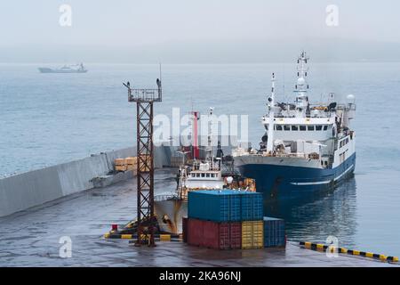 bateau de pêche à la jetée dans le port sur la rive d'une mer trouble Banque D'Images