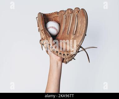 Le baseball est pris dans un gant de baseball porté. Banque D'Images