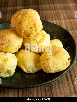 Pain au fromage brésilien connu sous le nom de pao de queijo en noir un contenant Banque D'Images