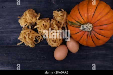 Cuisine de fond avec des nouilles de citrouille sur bois Banque D'Images