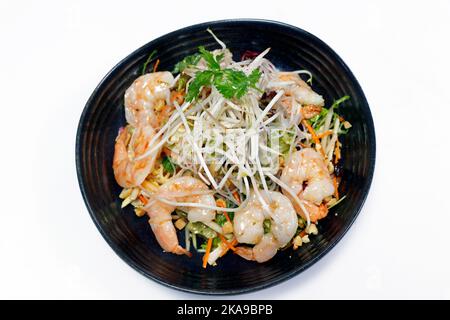 salade de crevettes épicée de style thaïlandais avec légumes croquants, arachides et pousses de haricots sur fond blanc Banque D'Images