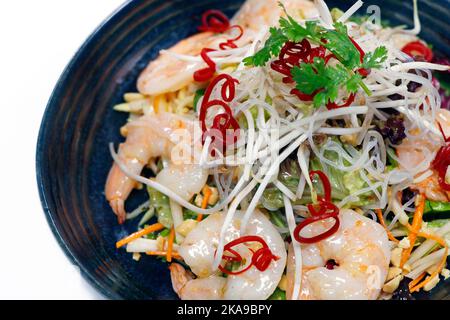 salade de crevettes épicée de style thaïlandais avec légumes croquants, arachides et pousses de haricots sur fond blanc, vue du dessus Banque D'Images