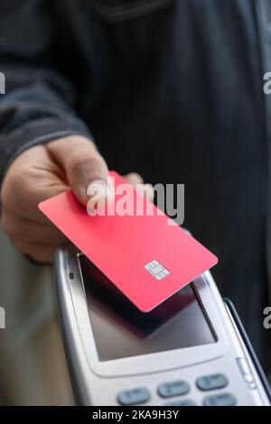 Client payant avec lecteur de carte de crédit dans un magasin Banque D'Images