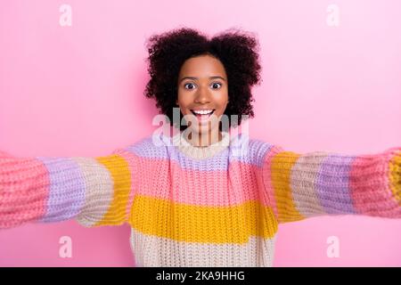 Portrait d'une fille impressionnée avec une coiffure ondulée sweat-shirt en tricot habillé faisant le selfie en regardant isolé sur fond de couleur rose Banque D'Images