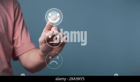 Concept de satisfaction du service client, jeune homme d'affaires touchant l'écran du visage heureux, sourire satisfaction rating icône face. Banque D'Images