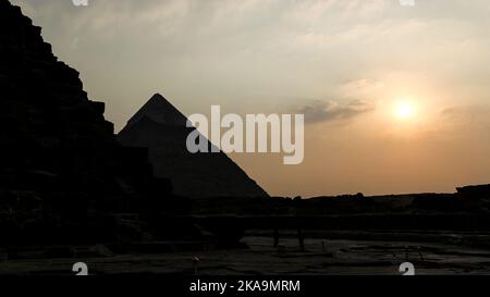 Une vue au coucher du soleil sur les grandes Pyramides de Gizeh en Égypte Banque D'Images