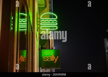 LONDRES - 2 novembre 2020 : l'enseigne de hamburger au néon Shake Shack au-dessus de l'enseigne Sally Beauty Store sur New Oxford Street la nuit Banque D'Images