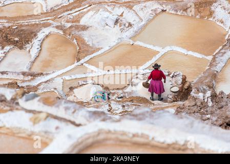 Femme extrayant du sel à Maras Pérou. Femme sur une robe colorée extraire le sel sur les terrasses salées, appelées Maras, près de Cusco, Pérou Banque D'Images