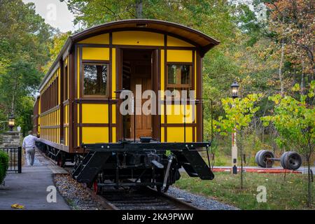 Elizabethtown, Pennsylvanie, 7 octobre 2020 - installation d'un nouvel autocar antique de passager jaune soulevé par une grue pour installer sur des camions de train sur une voie de chemin de fer le jour de l'automne Banque D'Images