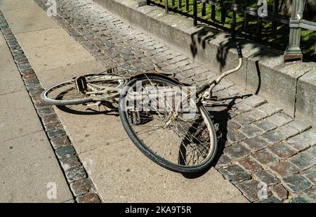 Une vieille bicyclette sale se trouve au milieu de la rue. Banque D'Images