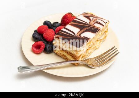 Pâtisserie Napoléon et mélange de baies colorées plaquées à la fourchette d'argent. Banque D'Images