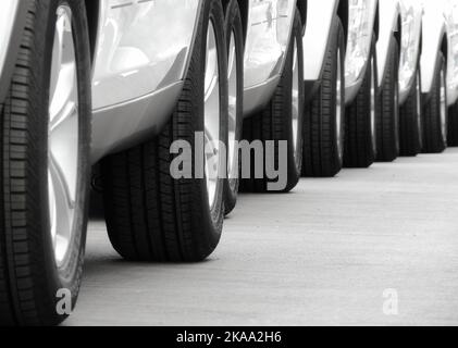 Roues de la même voiture blanche disposés dans des lignes sur l'asphalte Banque D'Images