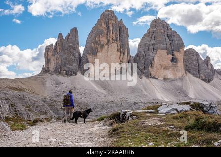 Une femme randonnée solitaire avec son chien autour des montagnes de Drei Zinnen, les Dolomites dans le Tyrol du Sud Banque D'Images