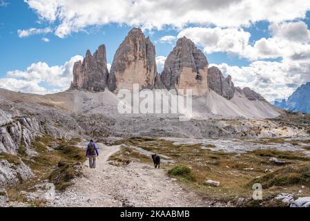 Une femme randonnée solitaire avec son chien autour des montagnes de Drei Zinnen, les Dolomites dans le Tyrol du Sud Banque D'Images