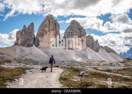 Une femme randonnée solitaire avec son chien autour des montagnes de Drei Zinnen, les Dolomites dans le Tyrol du Sud Banque D'Images