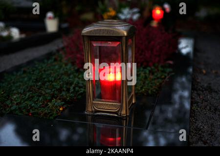 lanterne en métal avec bougie allumée sur une tombe au crépuscule Banque D'Images