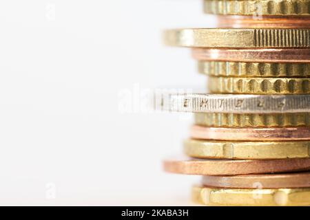 Empilez les pièces en euros sur la table avec un fond blanc et un espace pour copier sur le côté gauche Banque D'Images