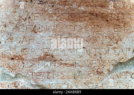 Texte antique grec antique et inscriptions sur le mur en pierre du temple. Culture grecque ancienne, alphabet et écriture de fond, concept d'histoire. Photo de haute qualité Banque D'Images