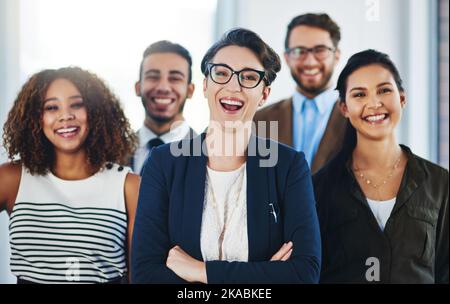 Succès, étaient à venir pour vous. Portrait d'une équipe diversifiée de professionnels debout ensemble dans un bureau. Banque D'Images