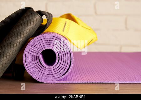 Tapis de fitness, poignées et cordes sur le sol dans la salle de gym moderne. Exercices actifs et équipement de formation Banque D'Images