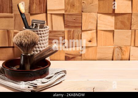 Lame de rasoir, brosse à dents et brosse à rasoir sur une table en bois. Objets vintage dans la salle de bains Banque D'Images