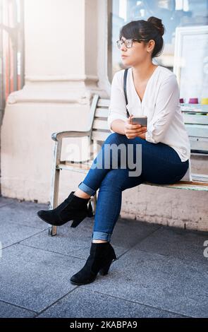 Voici mon tour. Une belle jeune femme assise sur un banc en attendant son tour. Banque D'Images