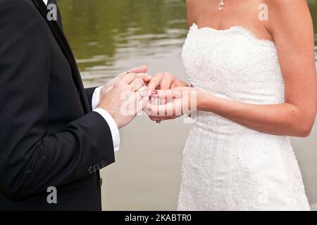 le couple de mariage est attachant la loyauté à vie dans le parc lors de la cérémonie de mariage Banque D'Images