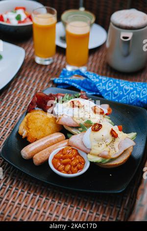 Oeuf benedict est servi sur une assiette noire avec un fond flou Banque D'Images