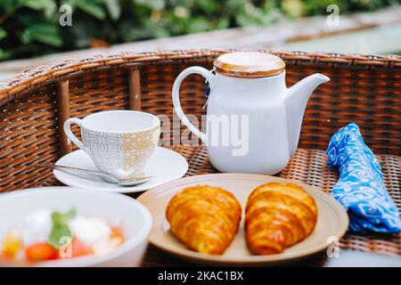 Une tasse vide et une théière dans un plateau en bois avec un premier plan et un arrière-plan flous Banque D'Images