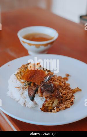 Photo verticale ou portrait d'une assiette de riz Nasi Babi Guling ou en rouleau de porc en anglais qui typique de la cuisine balinaise Banque D'Images