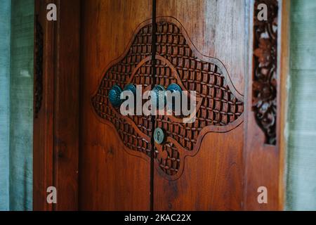 Porte en bois de teck sculptée avec des nuages artistiques dans un complexe à Ubud, Bali Banque D'Images