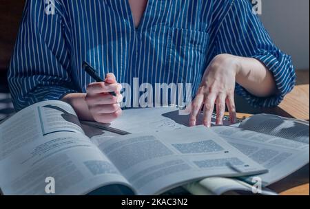 Minsk, Bélarus - octobre 22 2021 beaucoup de livres et de livres sur un bureau en bois dans un café ou une bibliothèque.Concept de recherche et de recherche de réponses dans les manuels scolaires. Banque D'Images