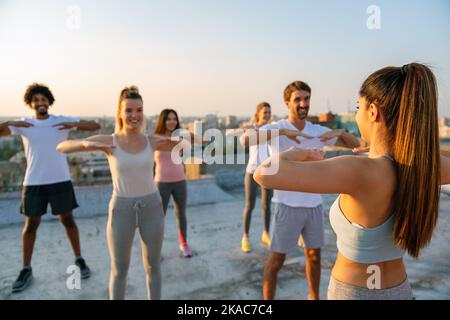 Groupe de personnes heureux de forme amis s'exerçant ensemble à l'extérieur pour rester en bonne santé Banque D'Images
