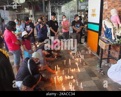 Calooan City, Philippines. 01st novembre 2022. Cimetière les visiteurs qui sont décédés parents tombeau est dans les provinces lointaines, éclairé des bougies devant la statue DE LA PIETA ou la statue de la Vierge Marie pleurant le corps mort de Jésus Christ pendant la Toussaint. Les Philippins affluent vers les cimetières après deux ans de pandémie de Covid-19, car ses restrictions ont commencé à s'assouplir lentement. La tradition d'apporter des fleurs, d'allumer des bougies et même d'offrir de la nourriture au lieu de sépulture de leurs amoureux partis. Crédit : SOPA Images Limited/Alamy Live News Banque D'Images